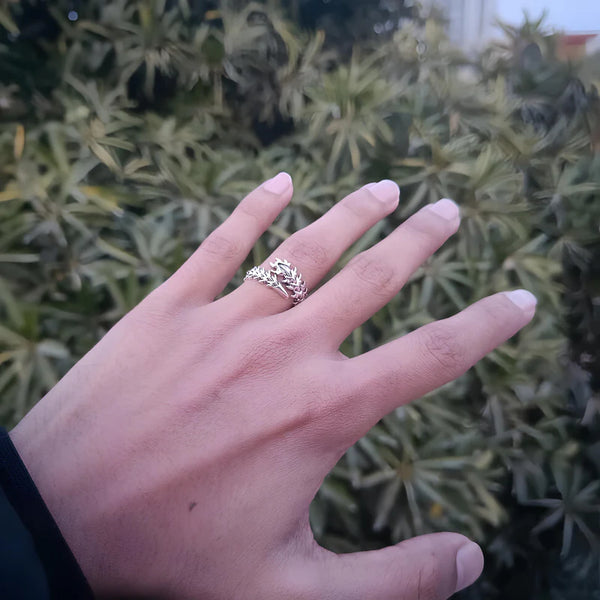 Bague Kaneki portée à la main, fond feuillage