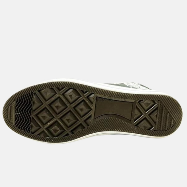 Détail de la semelle des baskets Bataillon d'exploration, montrant le logo et la qualité du caoutchouc.