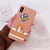 Coque beige pour iPhone avec une illustration "chibi" de Nami de One Piece, tenue en main.