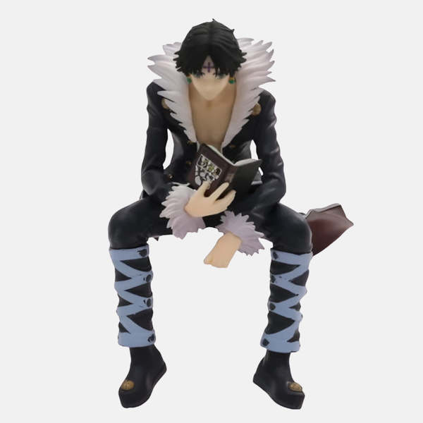 Figurine de Chrollo Lucilfer (14cm), vue de face, assis et lisant son livre de Nen "Le Secret du Voleur".