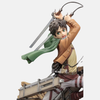 Figurine d'Eren Jäger de L'Attaque des Titans, en pose de combat sur un tronc d'arbre avec son équipement tridimensionnel et ses lames dégainées.