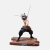 Figurine de Inosuke Hashibira de Demon Slayer dans une pose de combat animale, accroupi et prêt à bondir.
