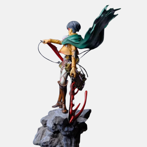 Vue de dos de la figurine de Livaï Ackerman, mettant en valeur sa cape verte flottante et la base en effet de fumée.