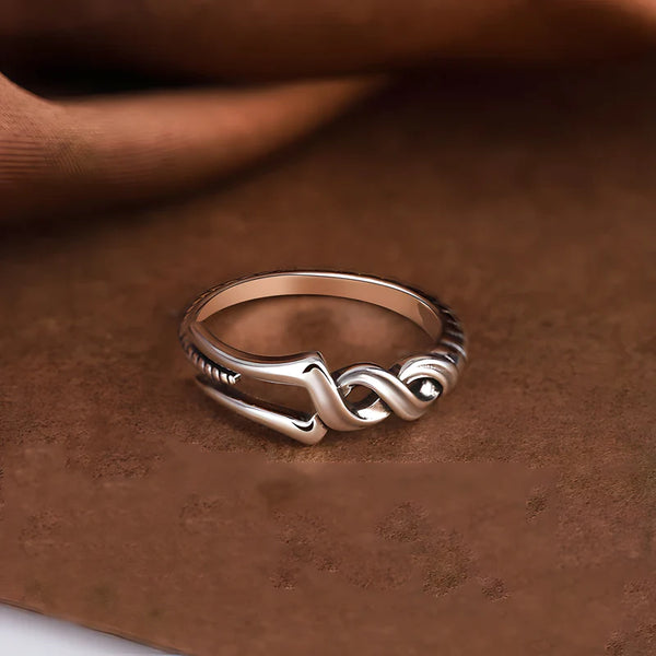 Gros plan sur les détails en spirale de la bague Longinus sur fond soyeux