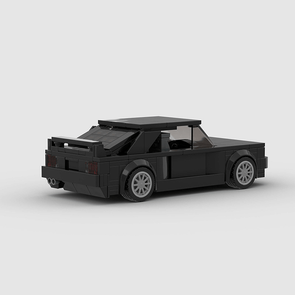 Vue de trois-quarts arrière de la BMW M3 E30 à construire, mettant en avant son aileron.