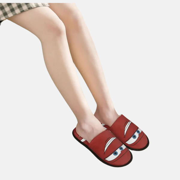 Personne portant les pantoufles Flash McQueen "Regard", montrant le style décontracté et facile à enfiler.