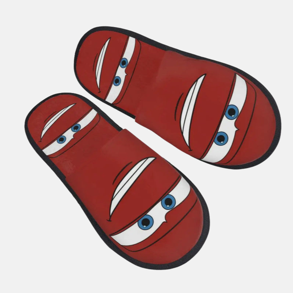 Paire de pantoufles rouges style mule avec le visage de Flash McQueen (yeux et sourire) imprimé sur le dessus.