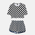 Ensemble pyjama femme Demon Slayer composé d'un crop top et d'un short assorti, arborant un motif à carreaux (damier) noir et blanc.