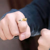 Bague Digimon portée au doigt par une main masculine