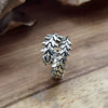 Bague Kaneki posée en diagonale sur une surface en bois
