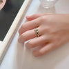 Femme portant la bague Longinus devant un miroir, style discret et chic