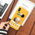Coque jaune pour iPhone avec une illustration "chibi" d'Usopp de One Piece, tenue en main.