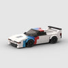 Vue de face de la BMW M1 Motorsport en briques, montrant la calandre et les phares emblématiques.