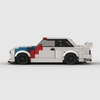 Vue de trois-quarts arrière de la BMW M3 E30 Motorsport à construire, mettant en avant son aileron.