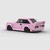 Vue de profil de la BMW M3 E30 rose en briques, montrant la longueur et les détails du modèle.