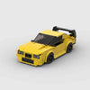 Kit de construction d'une BMW M3 E36 jaune en briques, montrant la vue de trois-quarts avant.